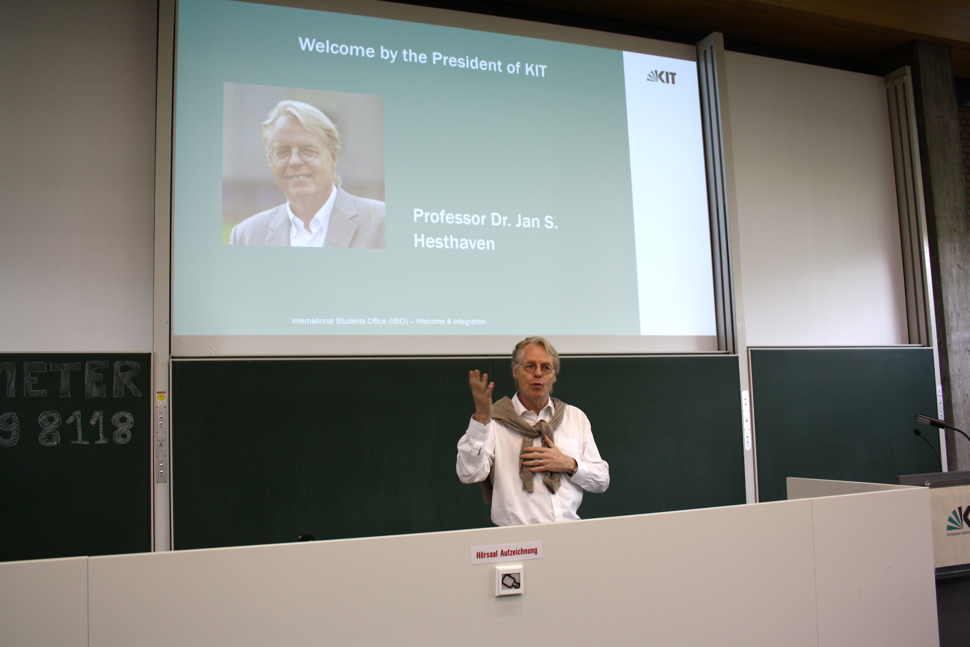 Professor Dr. Jan S. Hesthaven bei einem Vortrag vor einer Projektion seines Portr&auml;ts am KIT.
