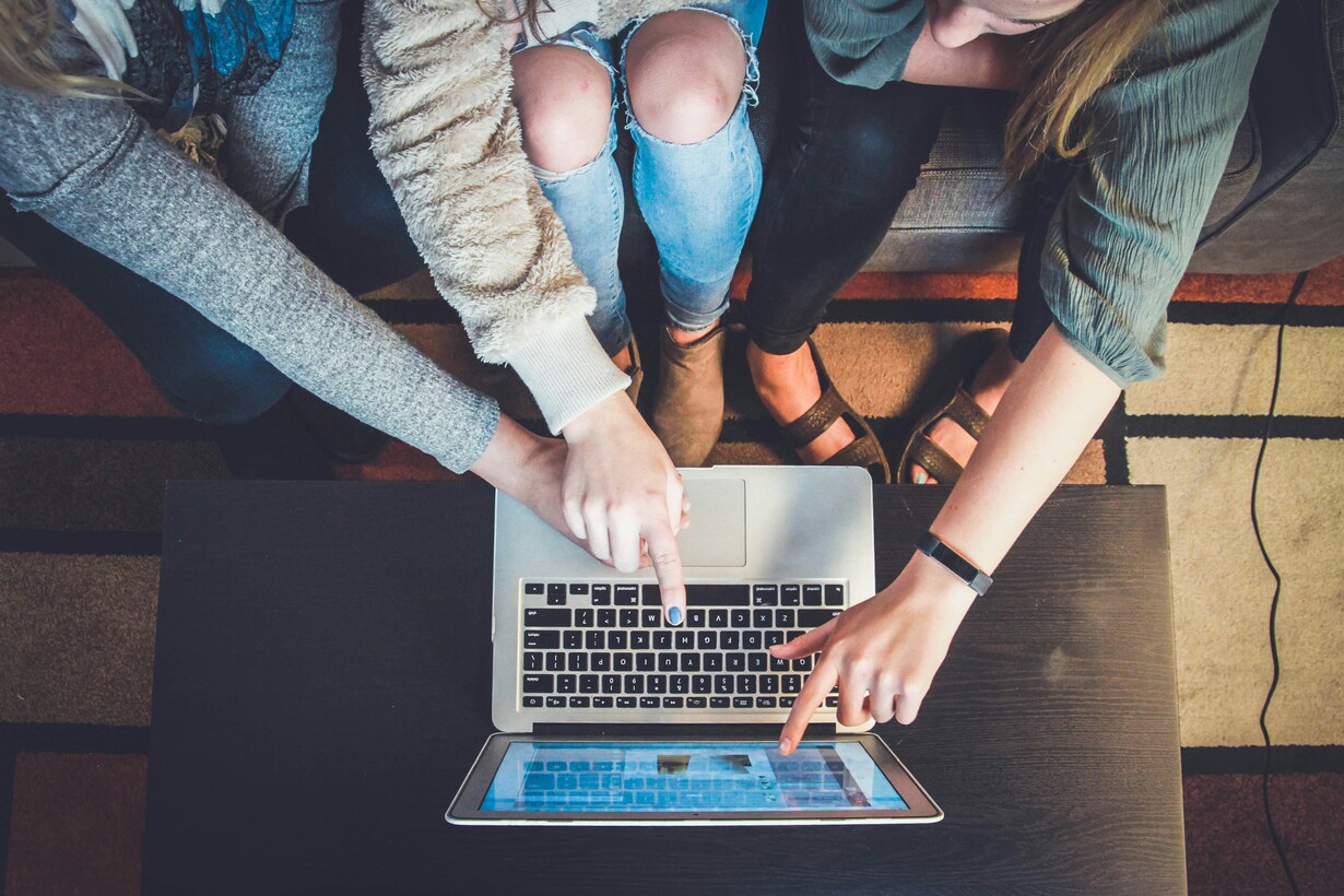 Studierende arbeiten gemeinsam an einem Laptop